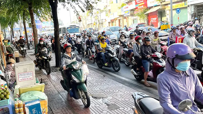 Nhiều người chạy xe máy lên vỉa hè đường Lý Thường Kiệt, phường Tân Sơn Nhất, TPHCM. Ảnh: HOÀNG HÙNG