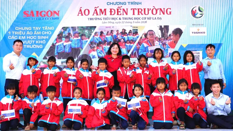 Phó Tổng Biên tập Báo SGGP Bùi Thị Hồng Sương cùng đại diện nhà tài trợ, Ban Giám hiệu Trường Tiểu học và THCS La Dạ trao học bổng cho các em học sinh