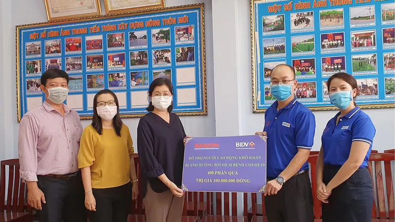 Đại diện Công đoàn BIDV trao tượng trưng cho đại diện Ban Biên tập Báo SGGP 400 phần quà giúp người nghèo vượt khó. Ảnh: LÊ NHUNG