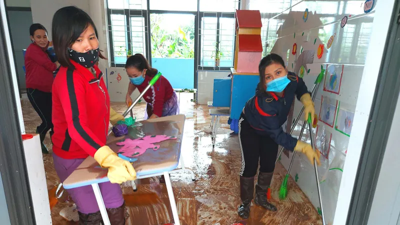 Giáo viên vùng lũ huyện Cẩm Xuyên, Hà Tĩnh dọn vệ sinh trường lớp sau lũ. Ảnh: DƯƠNG QUANG