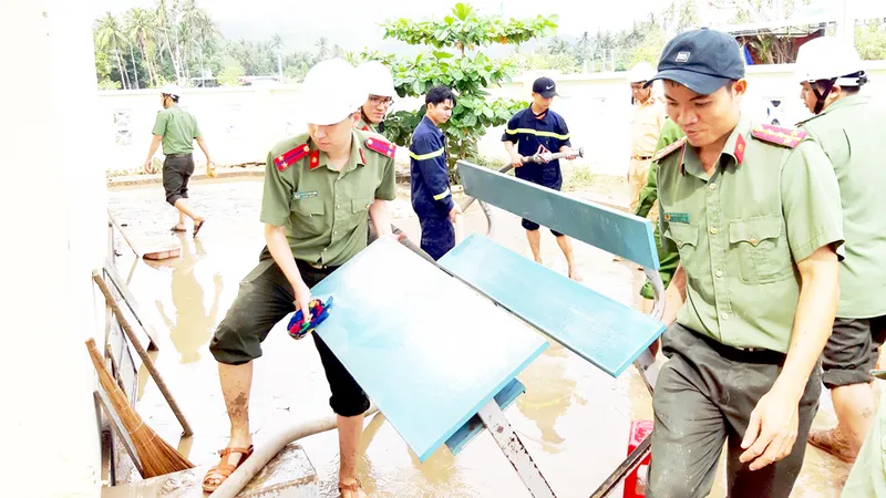 Công an tỉnh Phú Yên giúp người dân thị xã Sông Cầu khắc phục hậu quả bão số 12. Ảnh: XUÂN HUYÊN