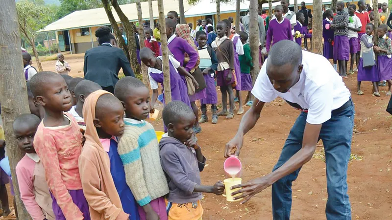 Trẻ em một trường học ở Kenya xếp hàng lấy cháo dinh dưỡng