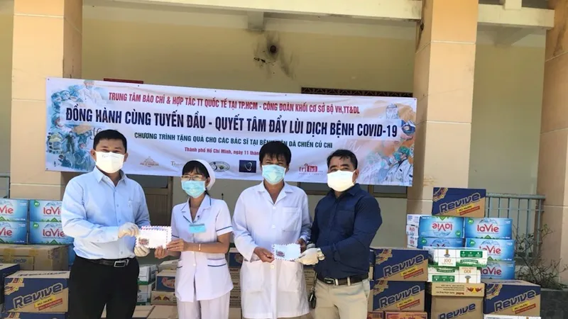 Giám đốc Trung tâm Báo chí và hợp tác truyền thông quốc tế tại TPHCM Lê Tự Phương Quang (trái) cùng mạnh thường quân trao quà hỗ trợ đội ngũ y, bác sĩ, các nhân viên y tế