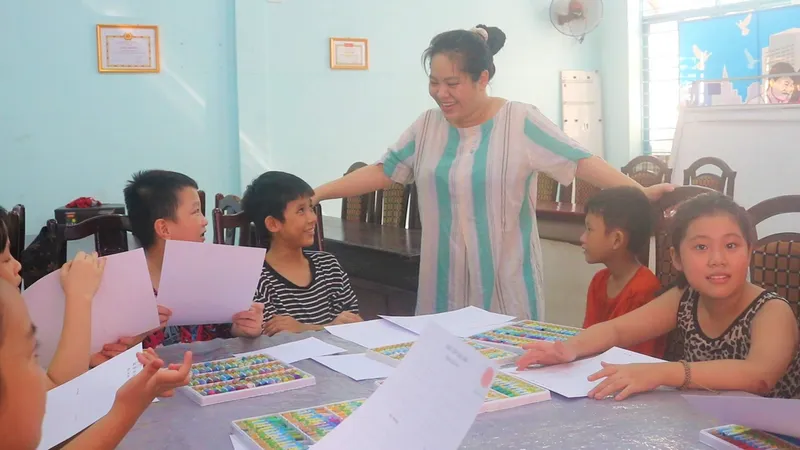 Cô Phạm Thị Nhật Nghi dạy vẽ miễn phí cho các em. Ảnh: XUÂN QUỲNH