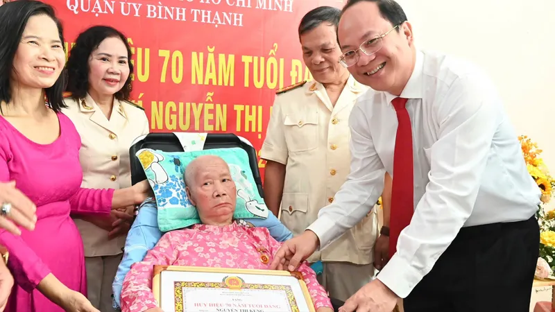 Phó Bí thư Thường trực Thành ủy TPHCM Nguyễn Hồ Hải trao Huy hiệu Đảng đến đồng chí Nguyễn Thị Keng. Ảnh VIỆT DŨNG