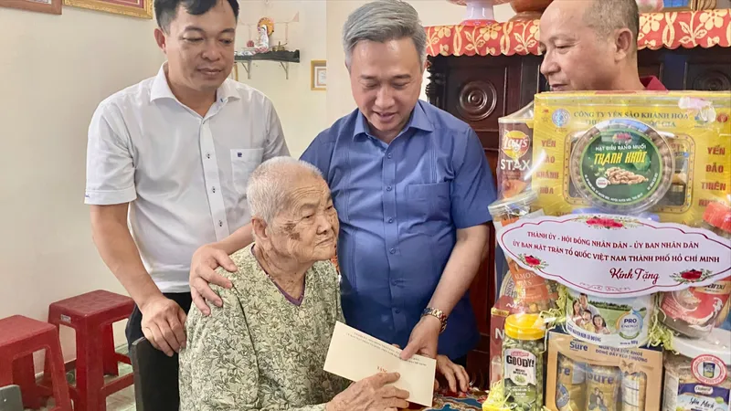 Phó Bí thư Thành ủy TPHCM Đặng Minh Thông thăm hỏi và tặng quà cho Mẹ Việt Nam Anh hùng Trần Thị Hiên. Ảnh: PHÚ NGÂN
