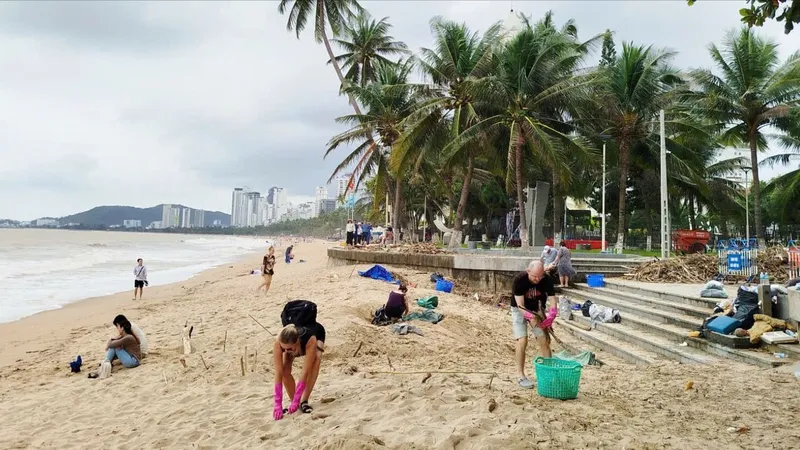 Du khách nước ngoài chung tay cùng người dân, cơ quan chức năng Khánh Hòa dọn dẹp bãi biển bị ảnh hưởng do mưa lũ