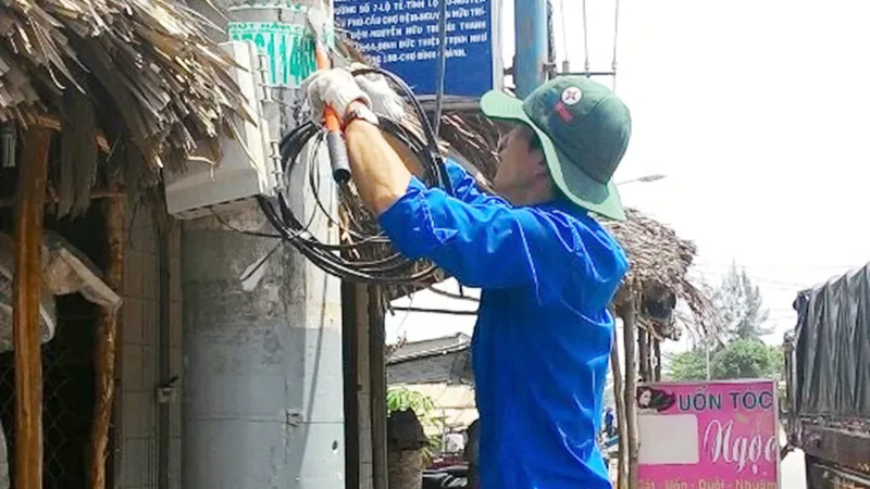 Thanh niên công nhân điện lực tham gia xóa lưới tạp để đảm bảo an toàn điện mùa mưa tại huyện Bình Chánh