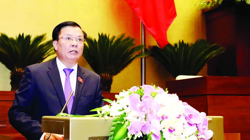 Bộ trưởng Bộ Tài chính Đinh Tiến Dũng trình bày báo cáo của Chính phủ tại kỳ họp. Ảnh: LÃ ANH