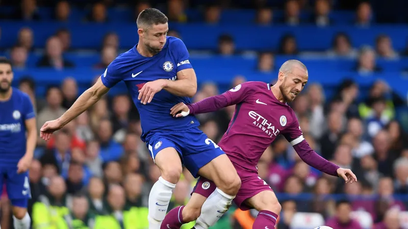 Gary Cahill (trái, Chelsea) tranh bóng với David Silva (Manchester City)