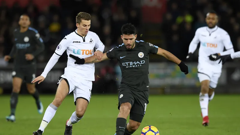 Kun Aguero đi bóng qua hậu vệ Swansea.