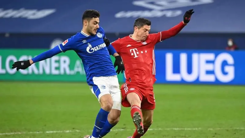 trung vệ Ozan Kabak tranh bóng với Rpobert Lewandowski của Bayern Munich