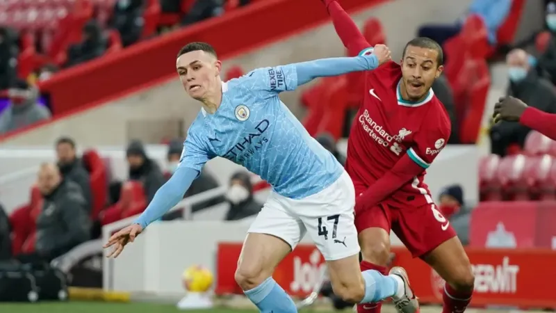 Phil Foden (trái) đi bóng qua Thiago 