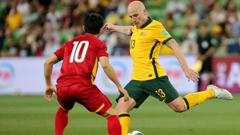 Aaron Mooy (phải) sẽ bỏ lỡ trận quyết định với Nhật Bản