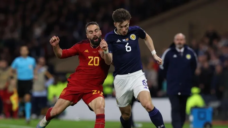 Dani Carvajal (Tây Ban Nha, trái) tranh bóng với Kieran Tierney (Scotland) 