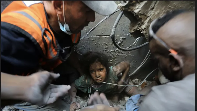 Người Palestine cứu một cô gái ra khỏi đống đổ nát của tòa bị phá hủy bởi cuộc không kích của Israel ở trại tị nạn Jabaliya, phía bắc Dải Gaza. Ảnh: AP 
