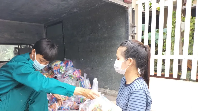 Người dân nhận nhu yếu phẩm do các nhà hảo tâm hỗ trợ. Ảnh: LÊ XUÂN