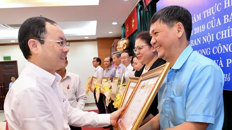 Phó Bí thư Thành ủy TPHCM Nguyễn Văn Hiếu trao bằng khen cho các tập thể. Ảnh: VIỆT DŨNG