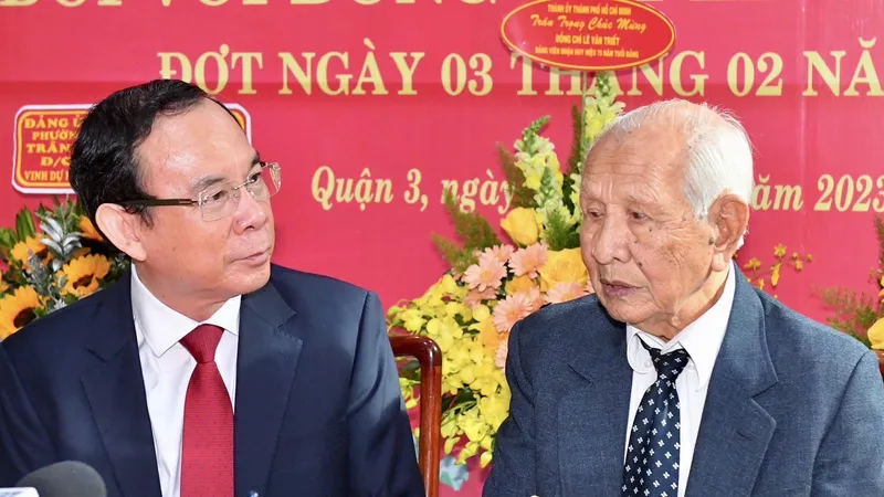 Bí thư Thành ủy TPHCM thăm hỏi, trò chuyện với đồng chí Lê Văn Triết tại lễ trao tặng Huy hiệu 75 năm tuổi Đảng. Ảnh: VIỆT DŨNG
