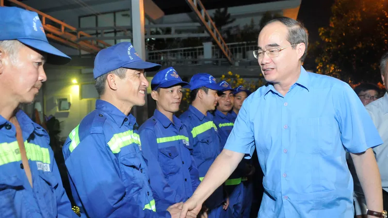 Đồng chí Nguyễn Thiện Nhân thăm hỏi công nhân Công ty TNHH MTV Môi trường đô thị TPHCM. Ảnh: CAO THĂNG