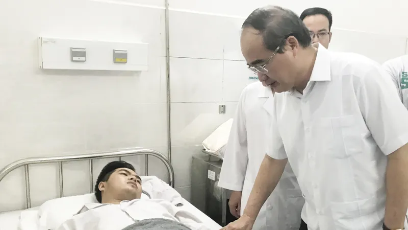 Bí thư Thành ủy TPHCM thăm hỏi “hiệp sĩ” Nguyễn Đức Huy. Ảnh: KIỀU PHONG