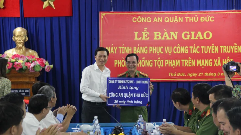 Đại tá Lê Anh Tuấn, Trưởng Công an quận Thủ Đức nhận máy tính bảng từ nhà tài trợ 