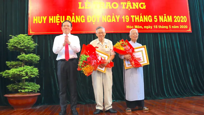  Đồng chí Trần Lưu Quang, Phó Bí thư Thường trực Thành ủy TPHCM trao Huy hiệu Đảng cho đảng viên cao tuổi Đảng thuộc Đảng bộ huyện Hóc Môn, sáng 18-5-2020. Ảnh: ANH CHÂU