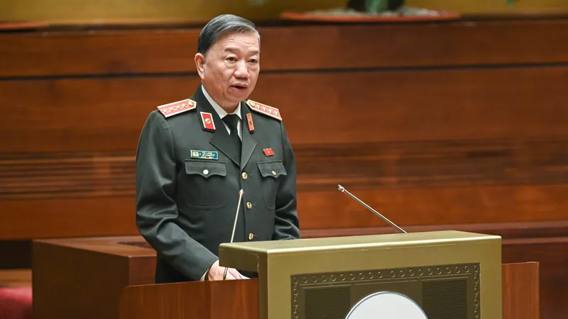 Bộ trưởng Bộ Công an Tô Lâm thay mặt Chính phủ trình Quốc hội tờ trình về thực hiện Luật Xuất cảnh, nhập cảnh của công dân Việt Nam liên quan tới thông tin “nơi sinh” trên hộ chiếu. Ảnh: VIẾT CHUNG