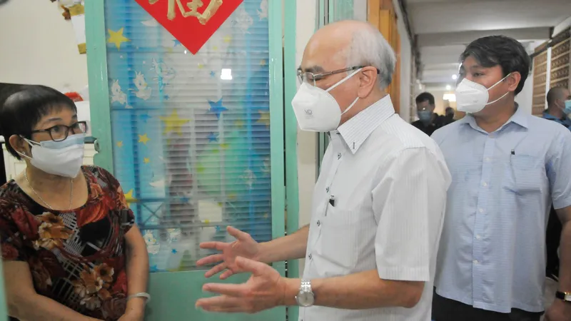 Trưởng Ban Tuyên giáo Thành ủy TPHCM thăm hỏi các hộ khó khăn ở khu vực “vùng xanh” tại chung cư 21-41 Tản Đà. Ảnh: CAO THĂNG