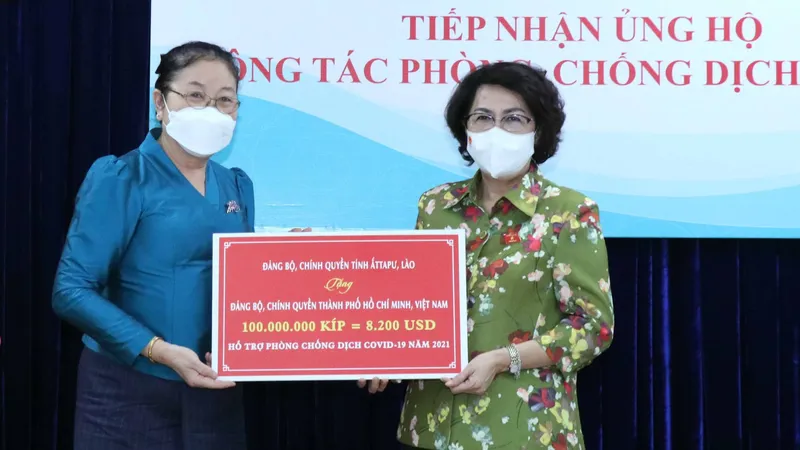 Chủ tịch Ủy ban MTTQ Việt Nam TPHCM Tô Thị Bích Châu tiếp nhận bảng tượng trưng ủng hộ do tỉnh Attapeu, Lào trao tặng