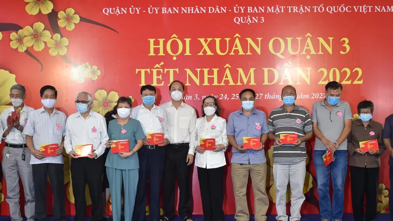 Phó Bí thư Thành ủy TPHCM Nguyễn Hồ Hải trao quà cho các gia đình chính sách. Ảnh: ĐÌNH LÝ