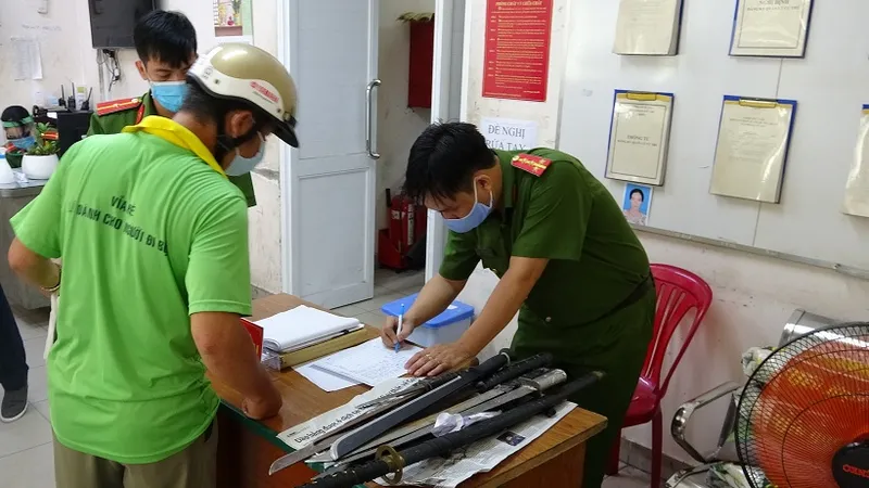 Người dân đến giao nộp vũ khí thô sơ. Ảnh: CA