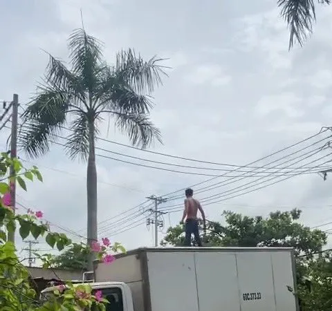 Người đàn ông nghi ngáo đá leo lên xe tải. Ảnh: VIẾT PHÓNG 