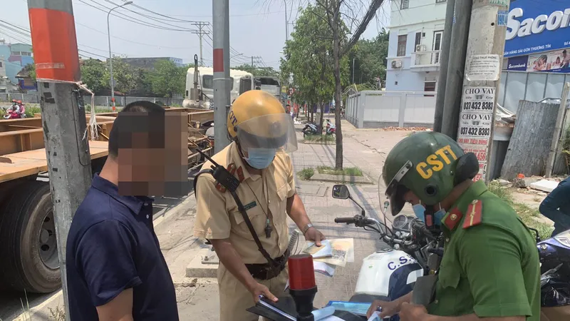 Lực lượng xử phạt một tài xế dừng đỗ ngay tại vòng xoay Phú Hữu. Ảnh: CHÍ THẠCH 