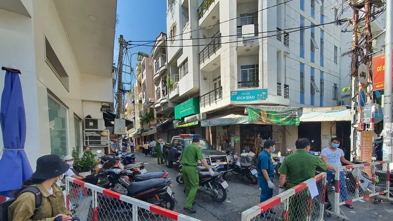 Lực lượng chức năng phong toả con hẻm có ca nghi mắc Covid-19. Ảnh: CHÂU TRỊNH 