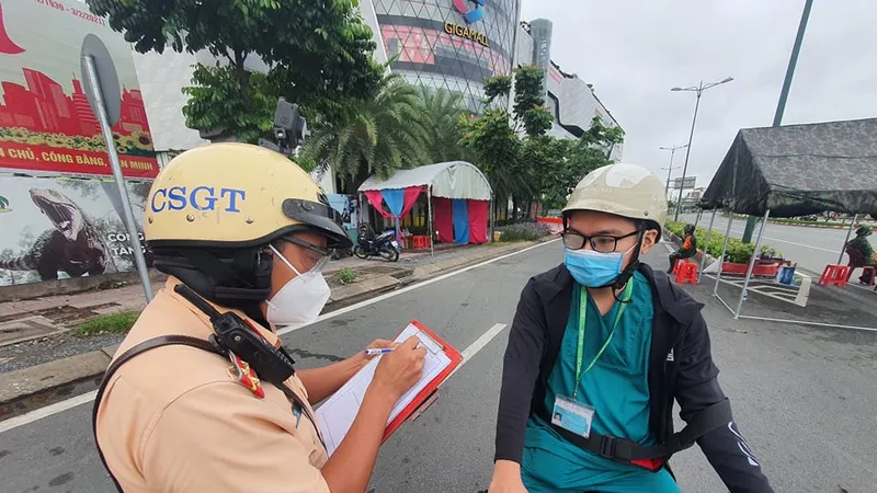 Lực lượng chức năng kiểm tra người dân tham gia lưu thông trên đường. Ảnh: CHÍ THẠCH 