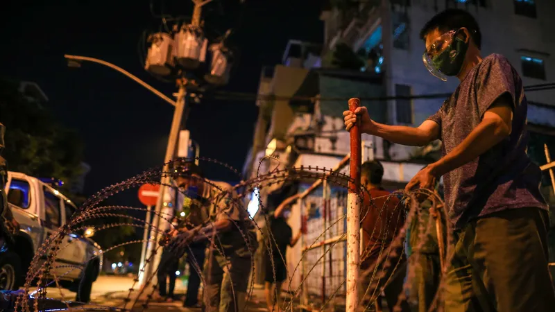 Lực lượng tháo gỡ rào chắn bằng khung sắt, dây kẽm thép gai ở giao lộ đườngTrần Minh Quyền – Điện Biên Phủ, phường 11, quận 10, TPHCM tối 29-9. Ảnh: DŨNG PHƯƠNG 