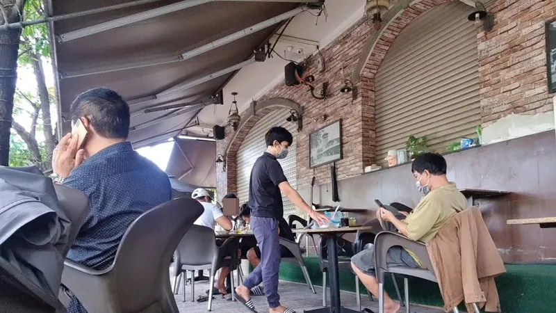 Nhiều khách ngồi tại bàn thoải mái uống cà phê nói chuyện không đeo khẩu trang. Ảnh: C.T