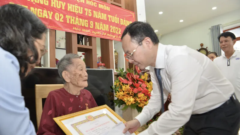 Phó Bí thư Thành uỷ TPHCM Nguyễn Văn Hiếu trao Huy hiệu 75 năm tuổi Đảng cho đồng chí Trịnh Thị Tẻo. Ảnh: CAO THĂNG 
