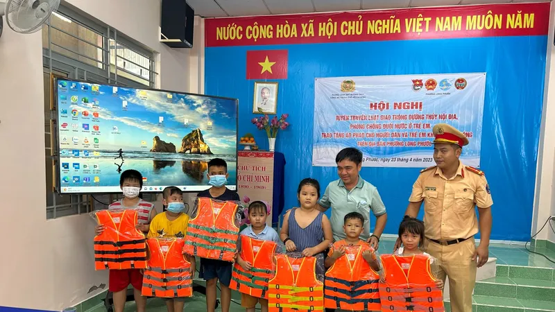 CSGT đường thủy hướng dẫn các em học sinh cách mặc áo phao phòng chống đuối nước