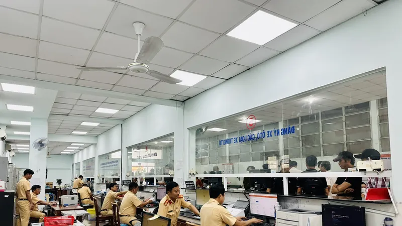 Cán bộ làm thủ tục cấp, thu hồi đăng ký, biển số xe cơ giới ở TPHCM. Ảnh: CHÍ THẠCH 