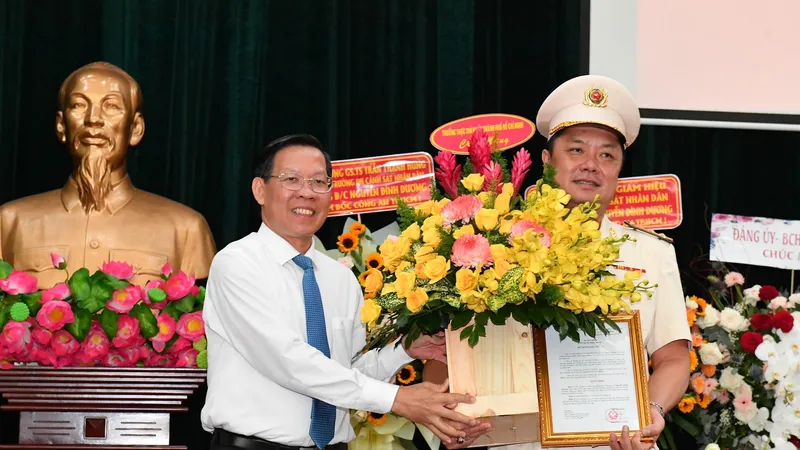 Chủ tịch UBND TPHCM Phan Văn Mãi chúc mừng tân Phó Giám đốc Công an TPHCM Nguyễn Đình Dương. Ảnh: VIỆT DŨNG 