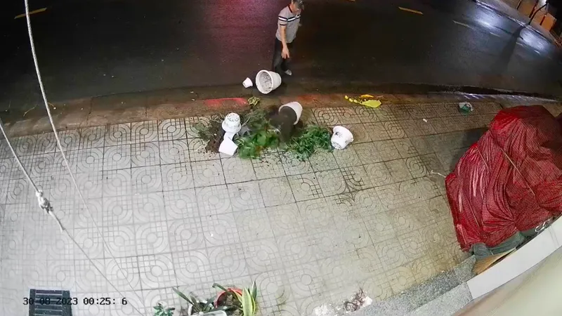 Hình ảnh đối tượng “khủng bố” bằng chậu cây trước tiệm vải nhà bà S. 