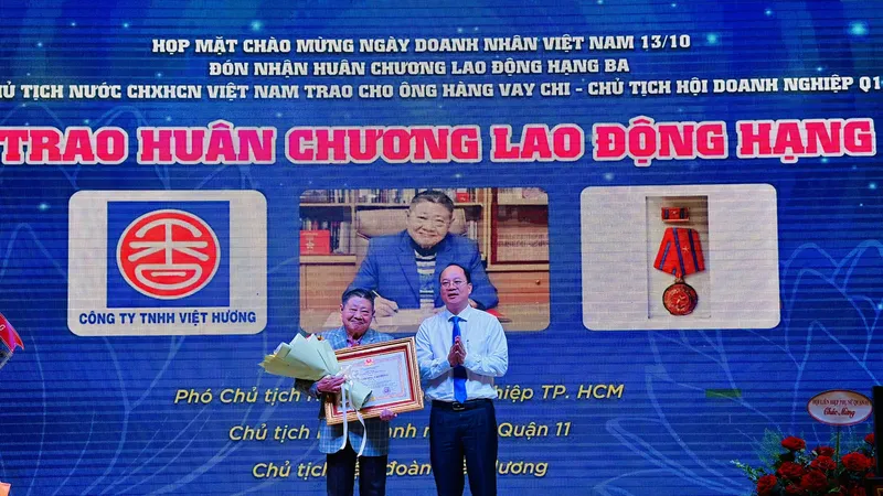 Phó Bí thư Thành ủy TPHCM Nguyễn Hồ Hải trao Huân chương lao động cho ông Hàng Vay Chi. Ảnh: CHÍ THẠCH