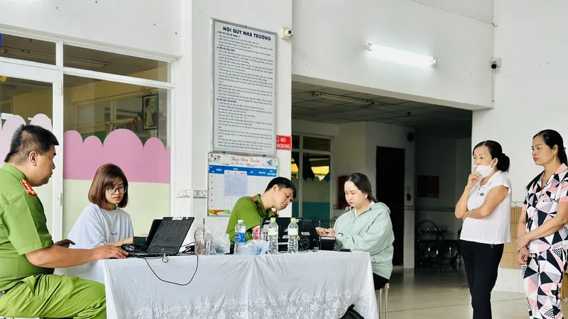 Cán bộ Công an TP Thủ Đức cấp khoản định danh điện tử mức 2 cho người dân. Ảnh CHÍ THẠCH