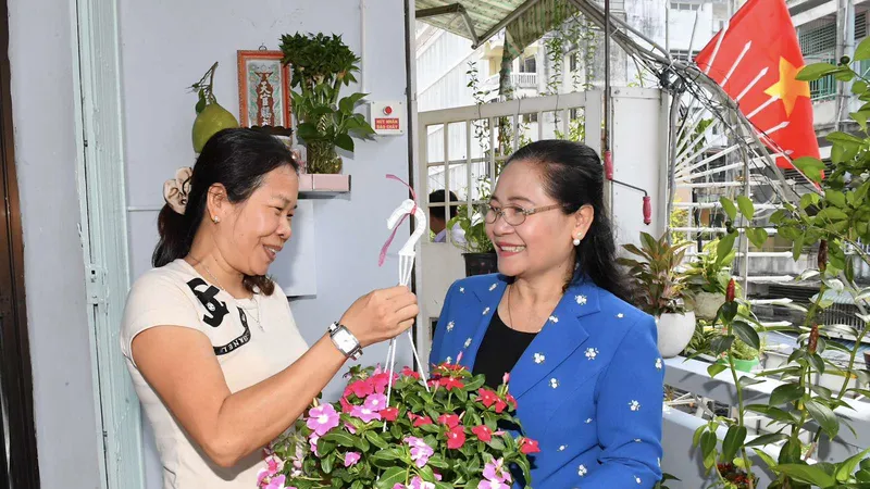 Chủ tịch HĐND TPHCM Nguyễn Thị Lệ tặng hoa cho các hộ dân. Ảnh: VIỆT DŨNG
