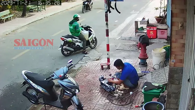 Nghi phạm mang can chứa xăng đứng trước con hẻm vào nhà bà D.