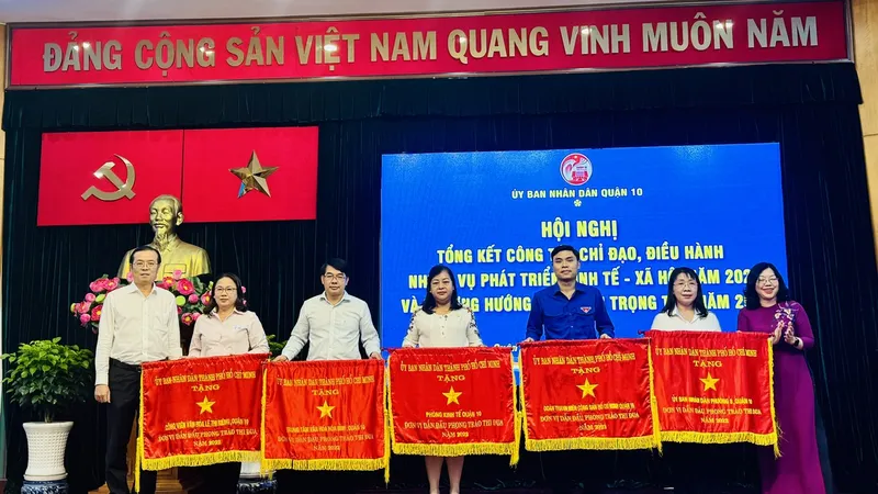 Lãnh đạo quận 10 tặng Cờ thi đua của UBND TPHCM cho 5 tập thể. Ảnh: CHÍ THẠCH 