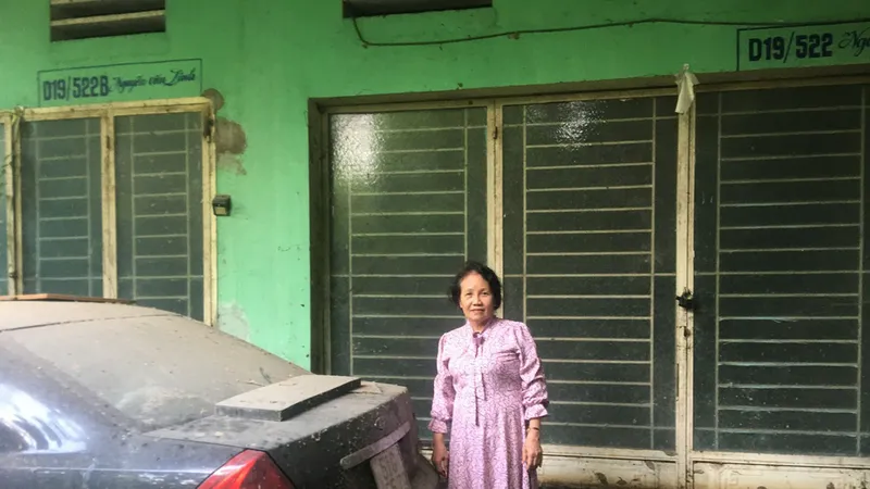 Bà Lưu Thị Thu trước ngôi nhà của mình đã bị ngâm nước lâu ngày, hư hỏng nặng
