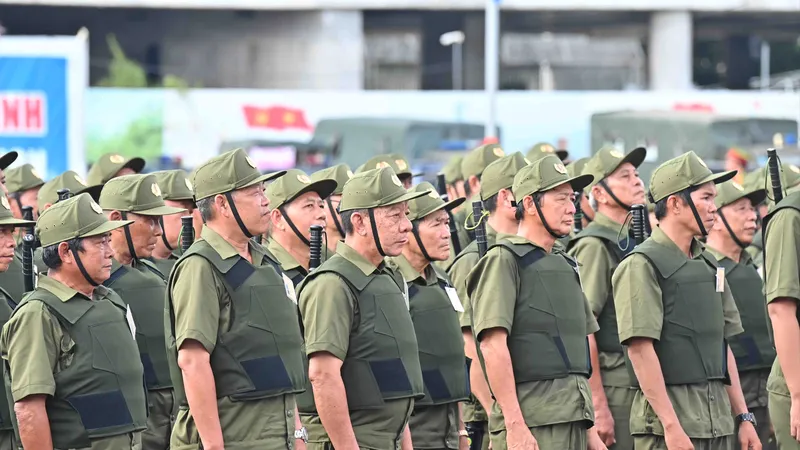 Lực lượng tham gia bảo vệ an ninh trật tự ở cơ sở tại buổi ra quân sáng 1-7. Ảnh: VIỆT DŨNG